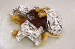 Arnaud’s chocolate delice with marshmallows, sliver leaf, banana and a rum sauce dessert o ...