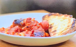 Tom Kerridge’s slow cooked campfire sausage and bean stew with smoked bacon and chorizo on ...