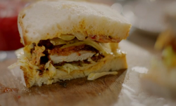 Nigella Lawson crispy fried chicken sandwich with homemade bread, ghurkins, kimchi and pink pick ...