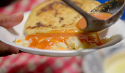 El Salvadorian Pupusa snack with corn tortilla, stuffed with meat, cheese, veg and served witj f ...